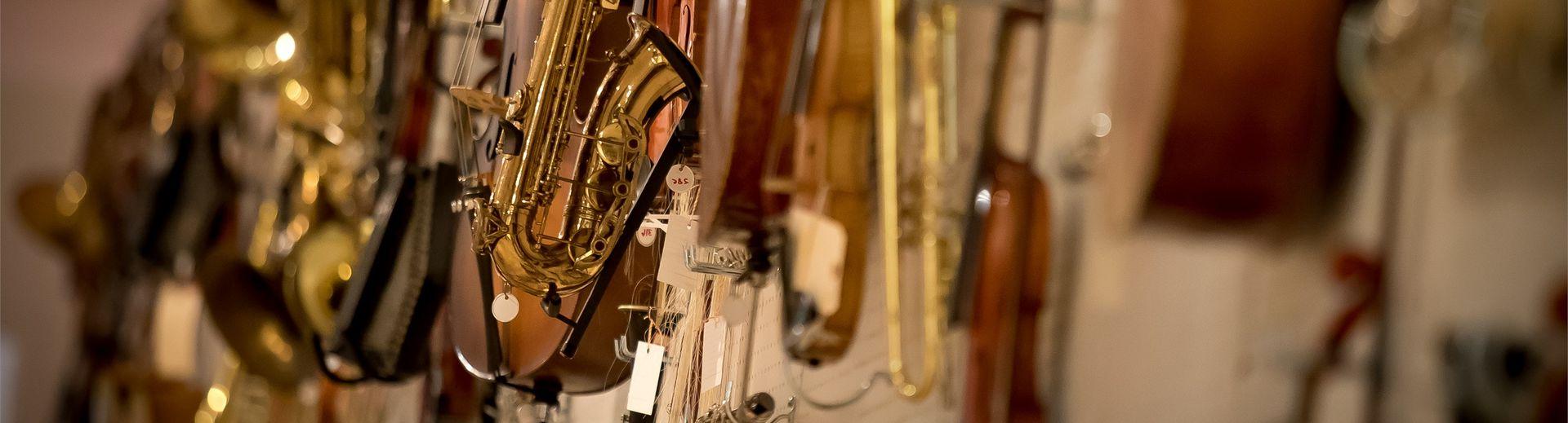 Several string and brass instruments hanging on a wall.