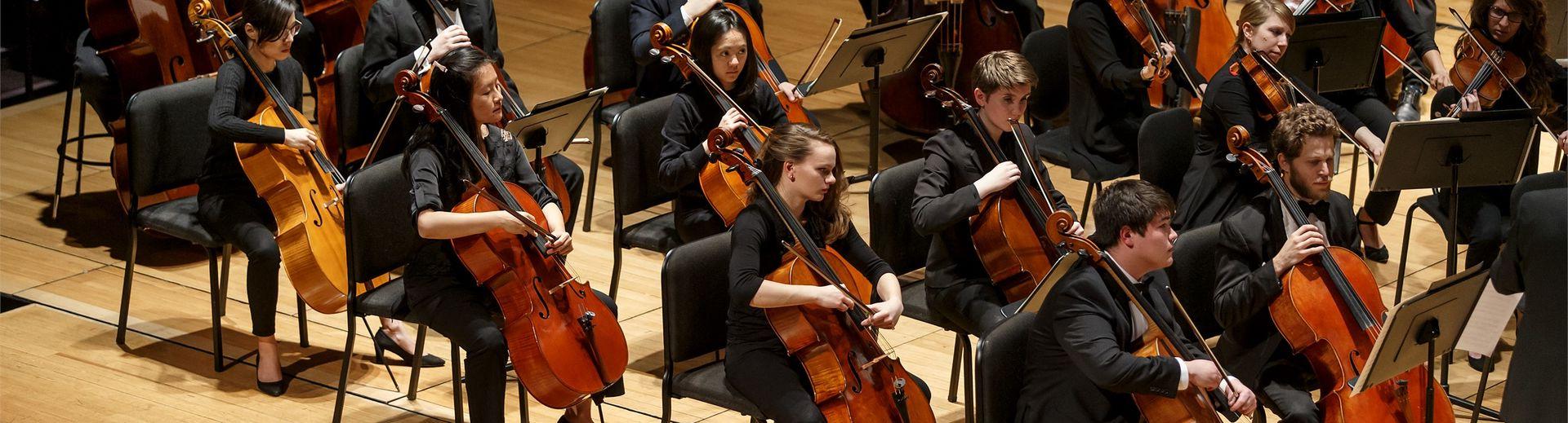 Student orchestra performing on stage.