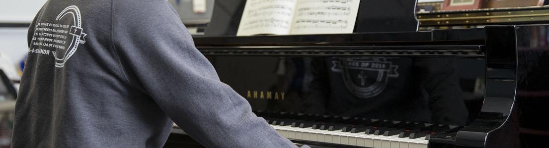 A Temple University student playing a piano.