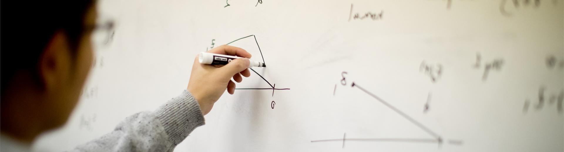 天普的学生在白板上解数学方程式.