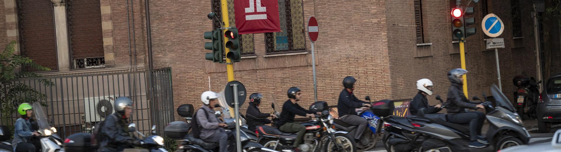 A group of people on motorcycles on an Italian street near Temple 罗马.