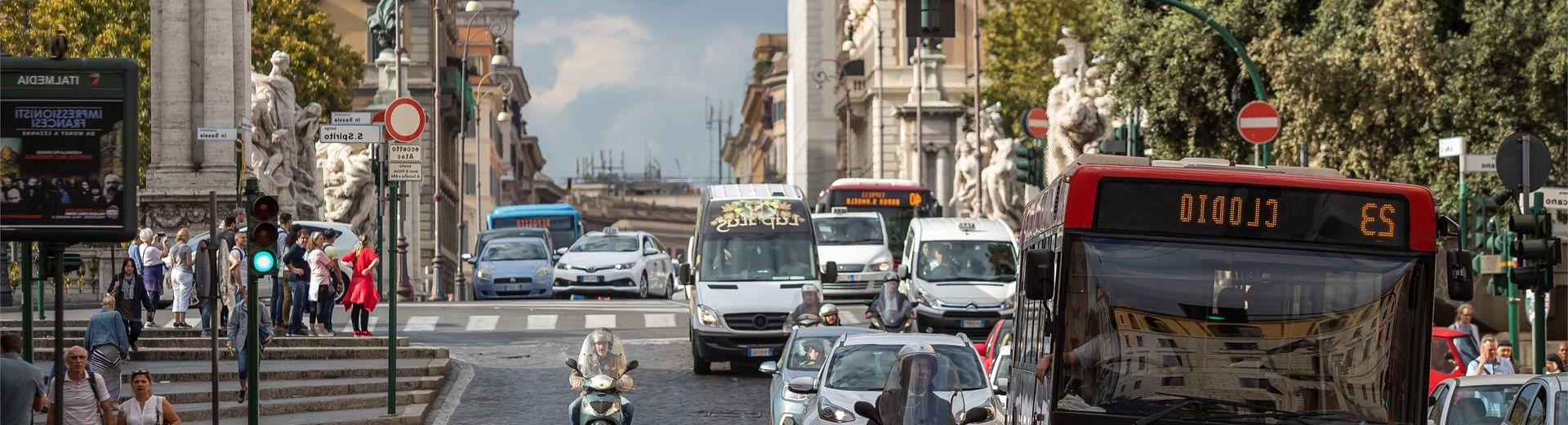 A bus, cars and scooters on a busy street in Rome, Italy.