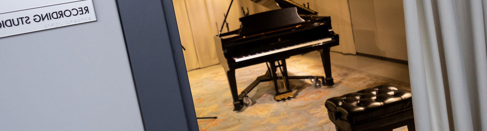 Practice room in music school with a grand piano and blue patterned carpet