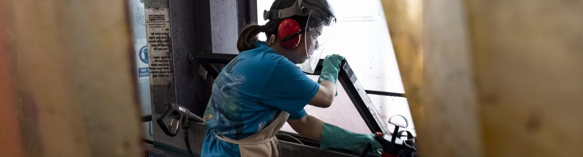 A printmaking student uses a hydrobooth to make a print.