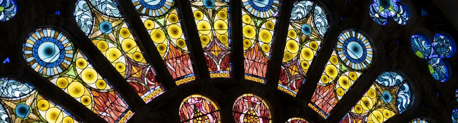 的 interior of a stained glass window with blue, green, yellow 和 red glass.