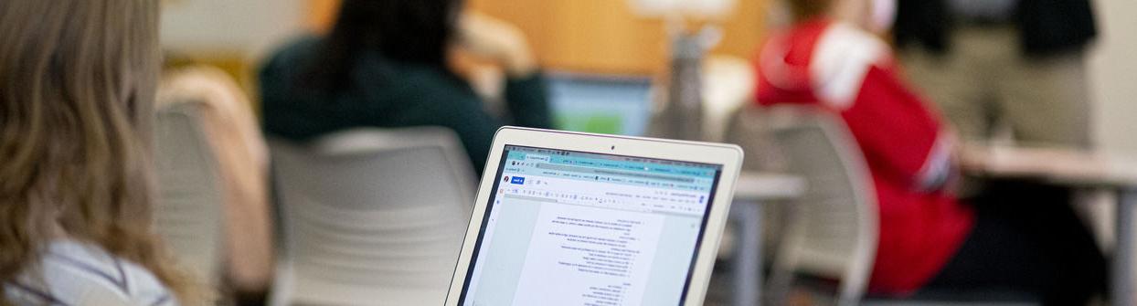 A Klein student taking notes during a class in public relations.