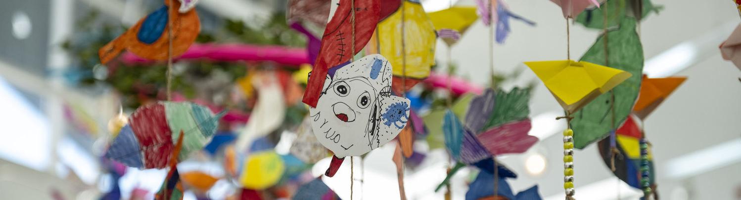 An image of several art projects made by young students hanging from the ceiling