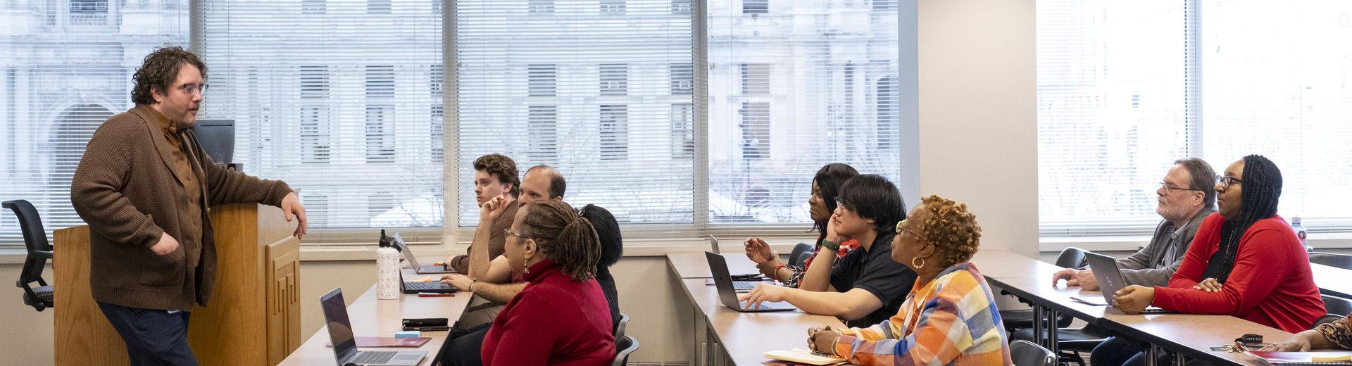 adult students listening to their instructor during class.