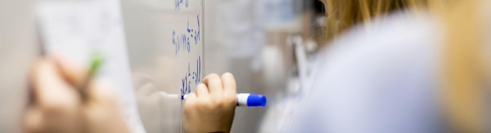 Temple students maps out complex problems on white board