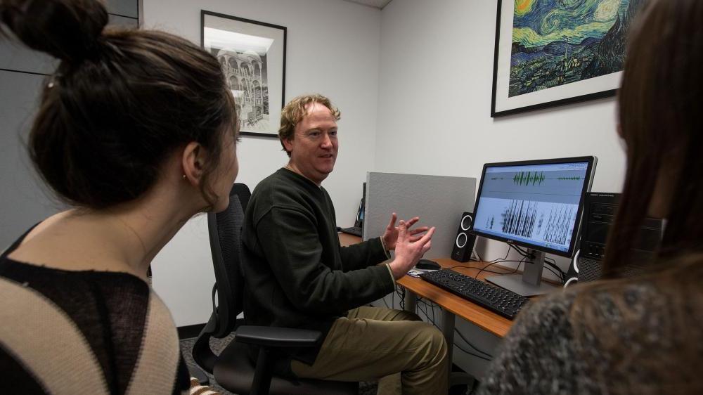 Linguistics professor with students in language lab