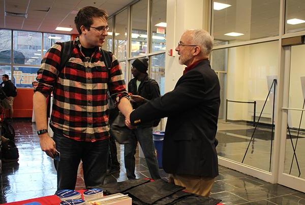 Engineering management certificate student shaking hands with faculty