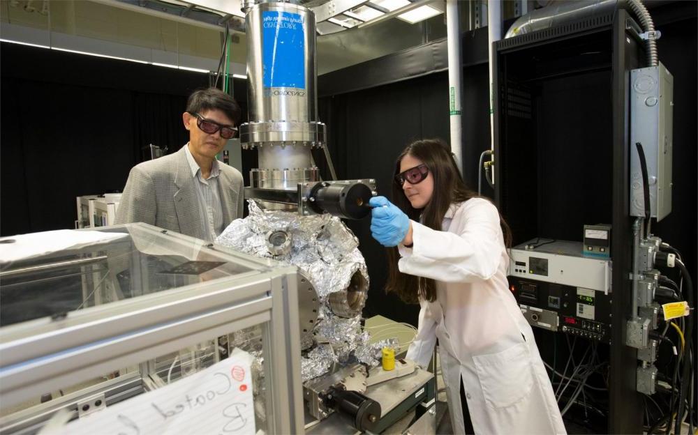 Temple faculty and students using complex machinery in a CST lab