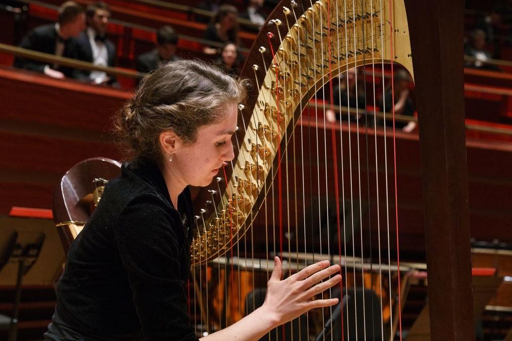 A Boyer College of Music and Dance student plays the harp during rehearsal.